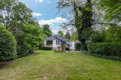 a yard with a white house with a picnic table at New Modern Home in Old Town in Niagara on the Lake