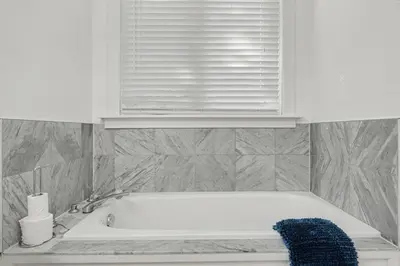 a white bath tub in a bathroom with a window at Upscale Modern Home with Spa Pool in Niagara on the Lake