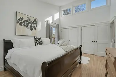 a bedroom with a large bed with white walls at Upscale Modern Home with Spa Pool in Niagara on the Lake