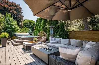 a patio with a couch and an umbrella at Upscale Modern Home with Spa Pool in Niagara on the Lake