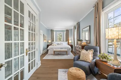 a room with a bedroom with a bed and a couch at Modern French Cottage in Old Town The 506 in Niagara on the Lake