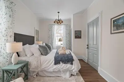 a bedroom with a bed with a stuffed animal on it at Modern French Cottage in Old Town The 506 in Niagara on the Lake