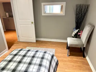 a room with a bed and a chair and a window at Beautiful walkout basement in Georgetown