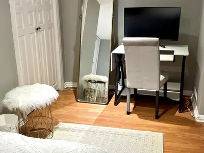 a bedroom with a desk with a computer and a chair at Beautiful walkout basement in Georgetown