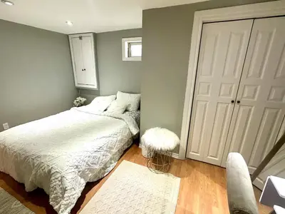 a bedroom with a bed and a mirror and a door at Beautiful walkout basement in Georgetown