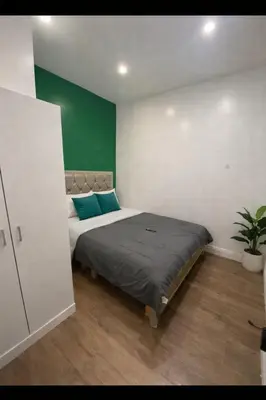 a bedroom with a large bed with a green wall at Pleasant Private Room In Cambridge 02 in Cambridge