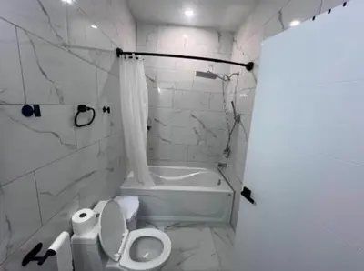 a white bathroom with a toilet and a bath tub at Pleasant Private Room In Cambridge 02 in Cambridge