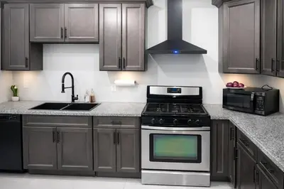 a kitchen with wooden cabinets and a stove and a sink at Pleasant Private Room In Cambridge 02 in Cambridge