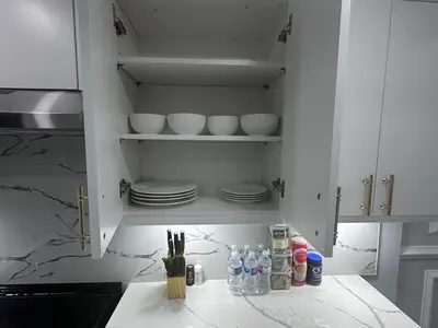 a kitchen with white cabinets and plates and utensils at Spacious 2 Bedroom, 1 Bathroom Luxury Apartment in Brampton
