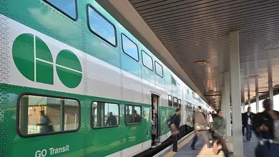 a green and white train in a train station with people walking by at Spacious 2 Bedroom, 1 Bathroom Luxury Apartment in Brampton