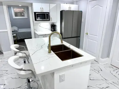 a white kitchen with a sink and a refrigerator at Spacious 2 Bedroom, 1 Bathroom Luxury Apartment in Brampton
