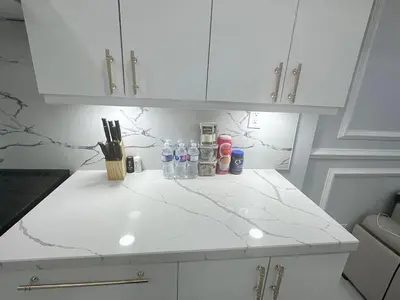 a kitchen counter with white cabinets and bottles on it at Spacious 2 Bedroom, 1 Bathroom Luxury Apartment in Brampton