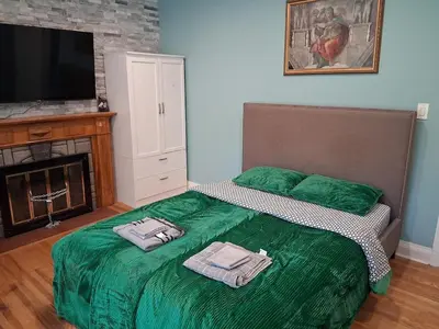 a bedroom with a green bed with two towels on it at Greenhills - 3 bedroom suit - main floor in Toronto