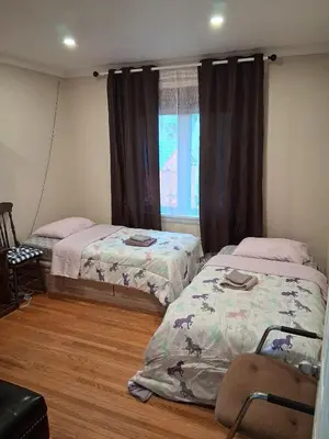 a bedroom with two beds and a window at Greenhills - 3 bedroom suit - main floor in Toronto