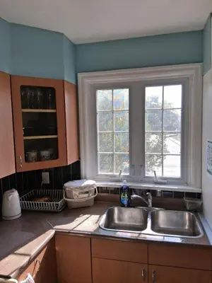 a kitchen with a sink and two windows at Greenhills - 3 bedroom suit - main floor in Toronto