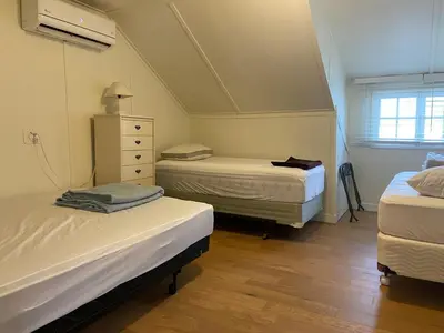 a room with two beds and a dresser in it at Waterfront Muskoka Cottage on Trent-Severn River in Severn