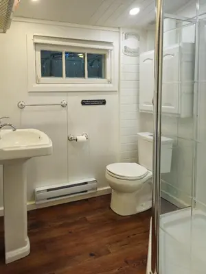 a bathroom with a toilet and a sink and a shower at Waterfront Muskoka Cottage on Trent-Severn River in Severn