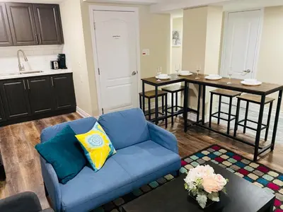 a living room with a blue couch and a kitchen at Relaxing 2 Bedroom Basement Stay in Mississauga