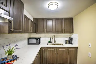 a kitchen with wooden cabinets and a sink at Relaxing 2 Bedroom Basement Stay in Mississauga