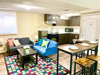 a living room with a blue couch and a kitchen at Relaxing 2 Bedroom Basement Stay in Mississauga