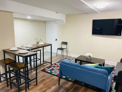 a living room with a blue couch and a table at Relaxing 2 Bedroom Basement Stay in Mississauga
