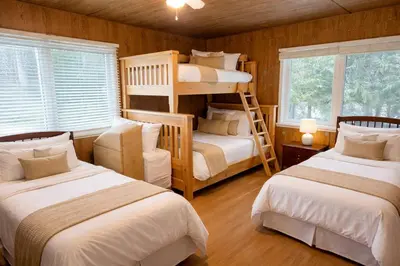 a bedroom with two bunk beds and a window at Private Lakehouse Getaway Hot Tub on the Water in Waubaushene
