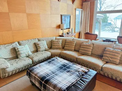 a living room with a couch and a table at Private Lakehouse Getaway Hot Tub on the Water in Waubaushene