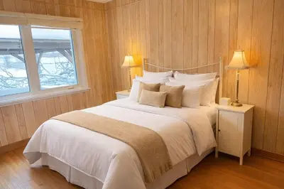 a bedroom with a large bed with white sheets and pillows at Private Lakehouse Getaway Hot Tub on the Water in Waubaushene