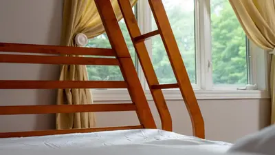 a wooden ladder next to a window in a bedroom at Muskoka 4-Bedroom Cottage in Port Carling