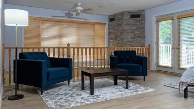 a living room with two blue chairs and a table at Muskoka 4-Bedroom Cottage in Port Carling