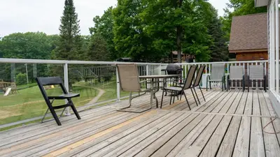 a wooden deck with chairs and a table on it at Muskoka 4-Bedroom Cottage in Port Carling