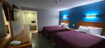 a hotel room with two beds and a blue wall at Avenue Motel in Mississauga