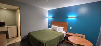 a hotel room with a bed and a table at Avenue Motel in Mississauga