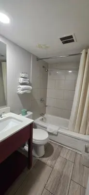a bathroom with a toilet and a tub and a sink at Avenue Motel in Mississauga