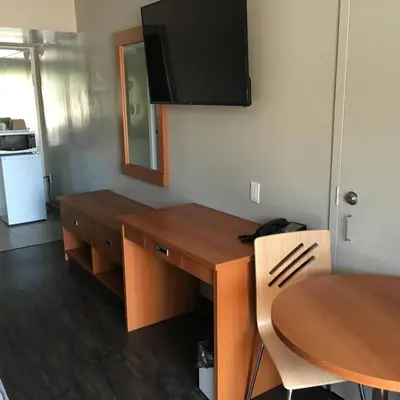 a kitchen with a desk and a table and a table and chairs at Avenue Motel in Mississauga