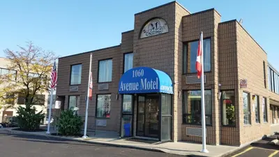 a large brick building with a clock on top of it at Avenue Motel in Mississauga
