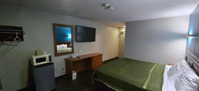 a hotel room with a bed and a microwave at Avenue Motel in Mississauga