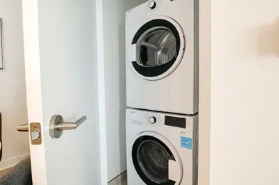 two washers and a dryer in a room at Modern High-Rise Condo w City Views & Balcony in Kitchener