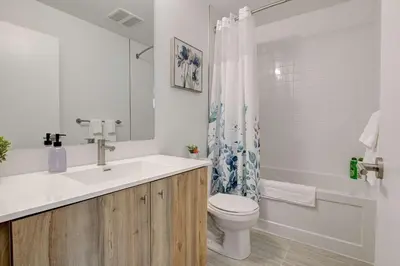 a white bathroom with a sink and a toilet at Modern High-Rise Condo w City Views & Balcony in Kitchener