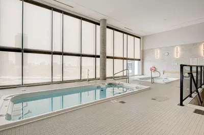 a large swimming pool in a large room with windows at Modern High-Rise Condo w City Views & Balcony in Kitchener