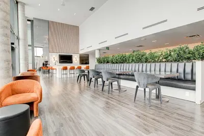 a lobby with chairs and a bar with plants at Modern High-Rise Condo w City Views & Balcony in Kitchener