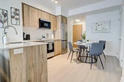 a kitchen and dining room with a table and chairs at Modern High-Rise Condo w City Views & Balcony in Kitchener