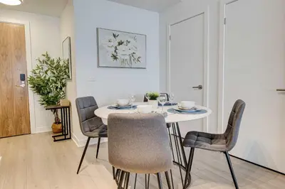 a dining room with a white table and chairs at Modern High-Rise Condo w City Views & Balcony in Kitchener