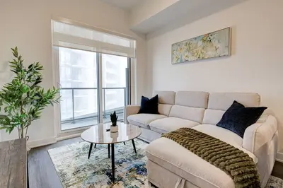 a living room with a couch and a table at Stylish Downtown Suite with Patio & City Views in Kitchener
