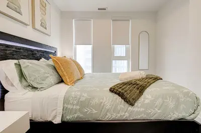 a bedroom with a bed with pillows on it at Stylish Downtown Suite with Patio & City Views in Kitchener