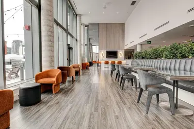 a restaurant with tables and chairs in a building at Stylish Downtown Suite with Patio & City Views in Kitchener