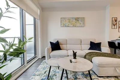 a living room with a couch and a table at Stylish Downtown Suite with Patio & City Views in Kitchener