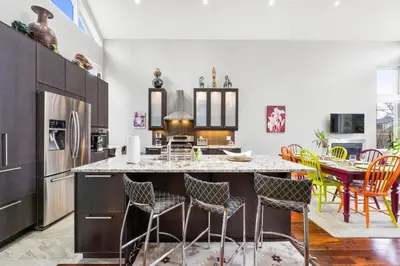 a kitchen with a large island with chairs and a table at Beautiful 3BR Old Town Home Steps to Queen St in Niagara on the Lake