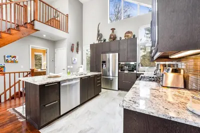 a large kitchen with wooden cabinets and stainless steel appliances at Beautiful 3BR Old Town Home Steps to Queen St in Niagara on the Lake