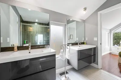 a bathroom with two sinks and a large mirror at Beautiful 3BR Old Town Home Steps to Queen St in Niagara on the Lake